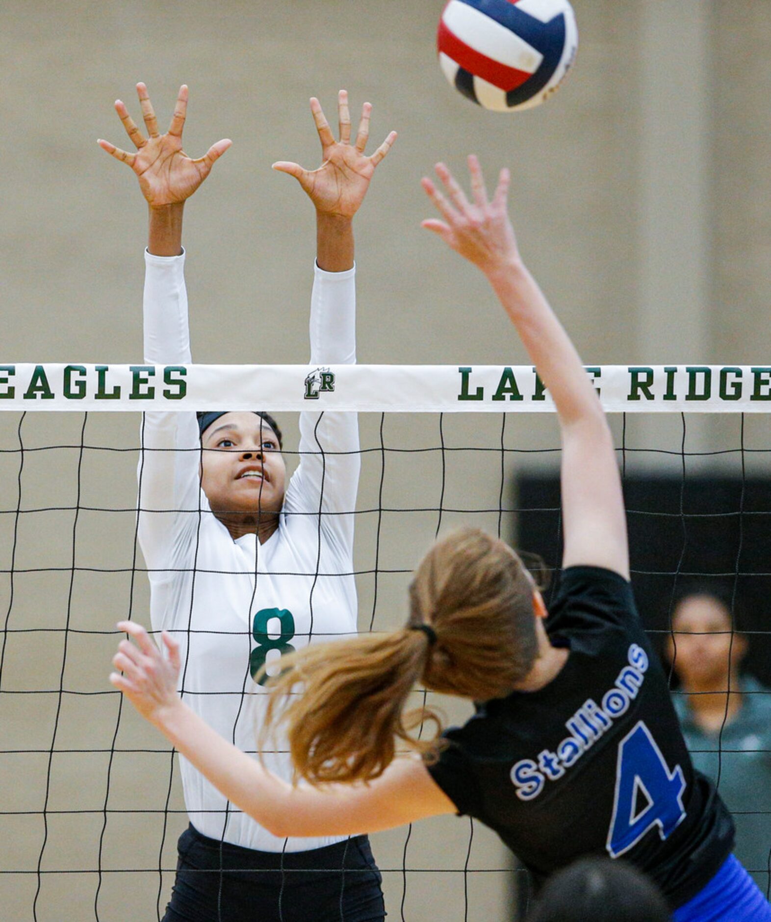 Mansfield Lake Ridge junior Lyric Stewart (8) attempts to block a spike by North Mesquite...