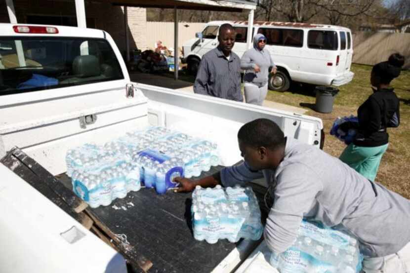 
Sandbranch resident Elijah Bryant, 8, delivers cases of water from Mount Zion Baptist...