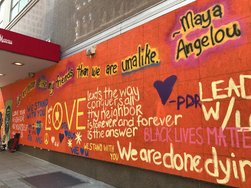 Boarded-up downtown Dallas Neiman Marcus windows are painted with supportive messages for...