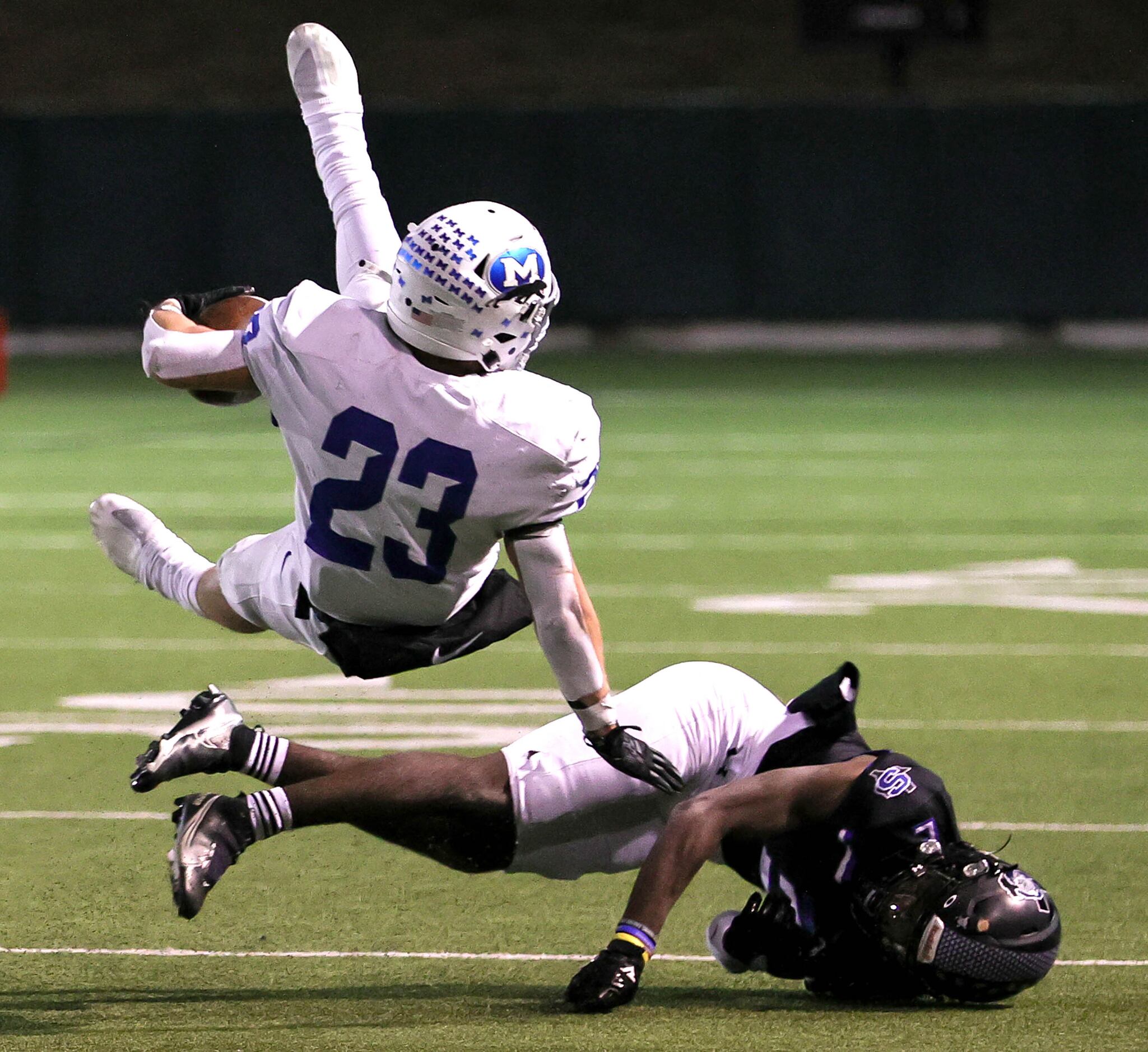 Midlothian running back Kaden Smith (23) gets tripped up by Mansfield Summit defensive back...