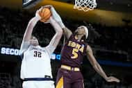 Iona's Daniss Jenkins (5) blocks a shot by Connecticut's center Donovan Clingan (32) in the...