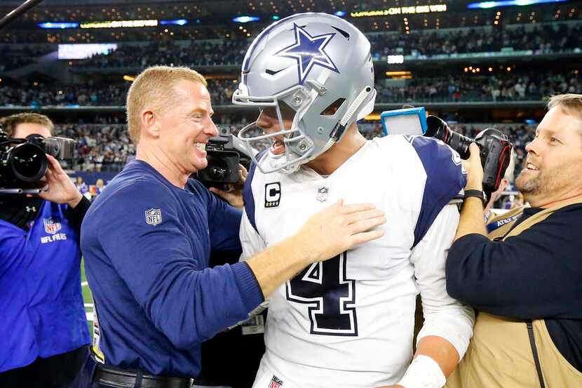 Dallas Cowboys head coach Jason Garrett congratulates quarterback Dak Prescott (4) on the...