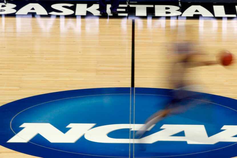 FILE - In this March 14, 2012, file photo, a player runs across the NCAA logo during...