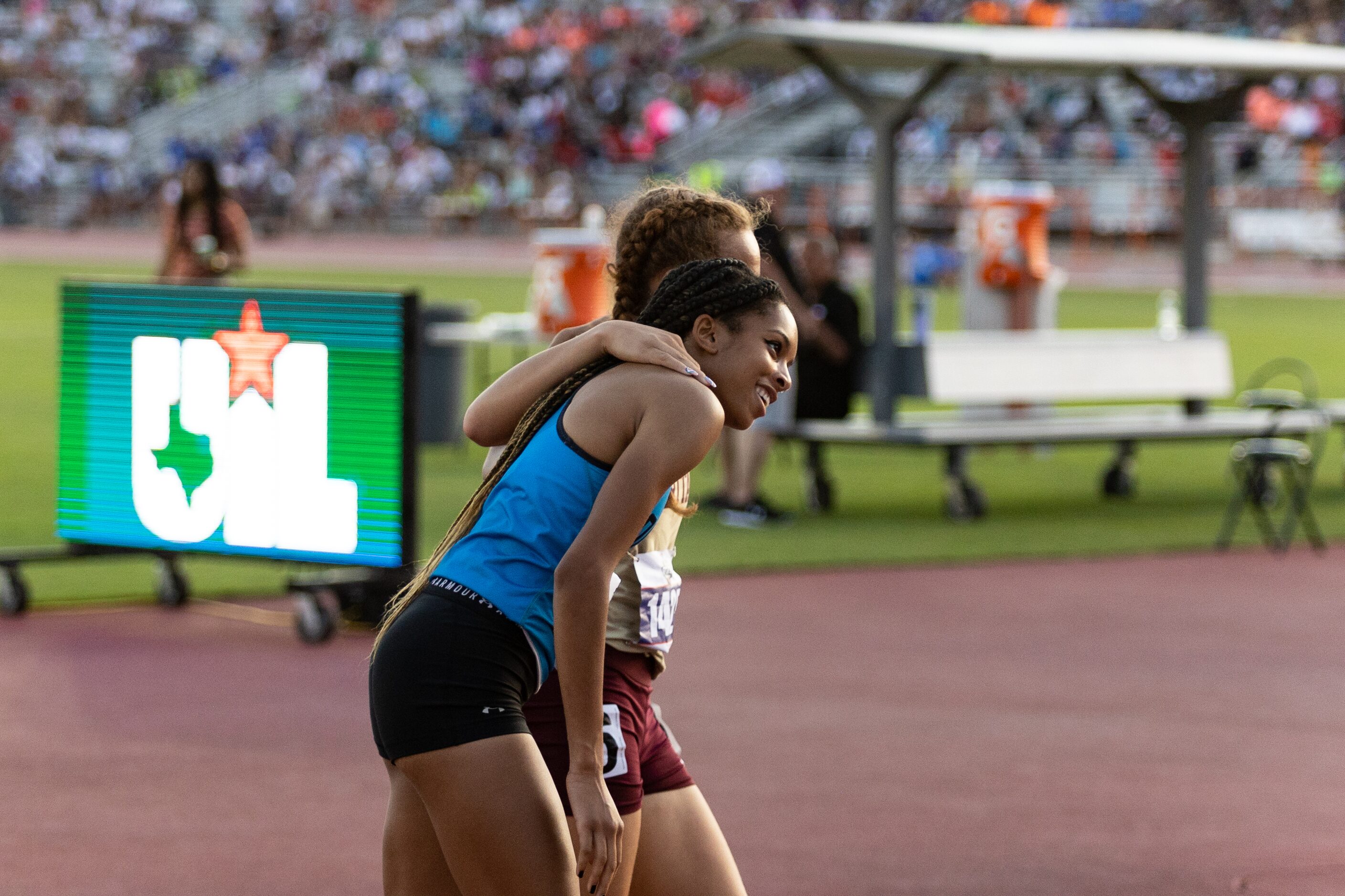 Jourdin Edwards of Prosper Rock Hill walks off the track, embraced by Kirin Chacchia of...