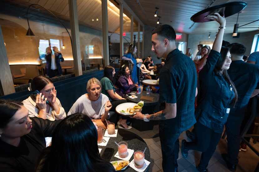Waiter Eduardo Luna serves customers at the upstairs bar during a preview of the new Mi...