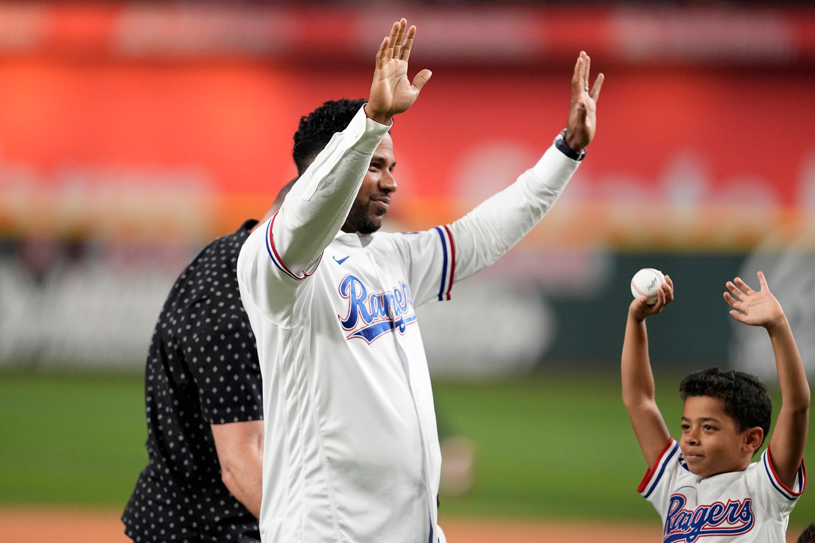 Former Texas Rangers player Elvis Andrus, left, and his son Elvis Jr., right waves to...