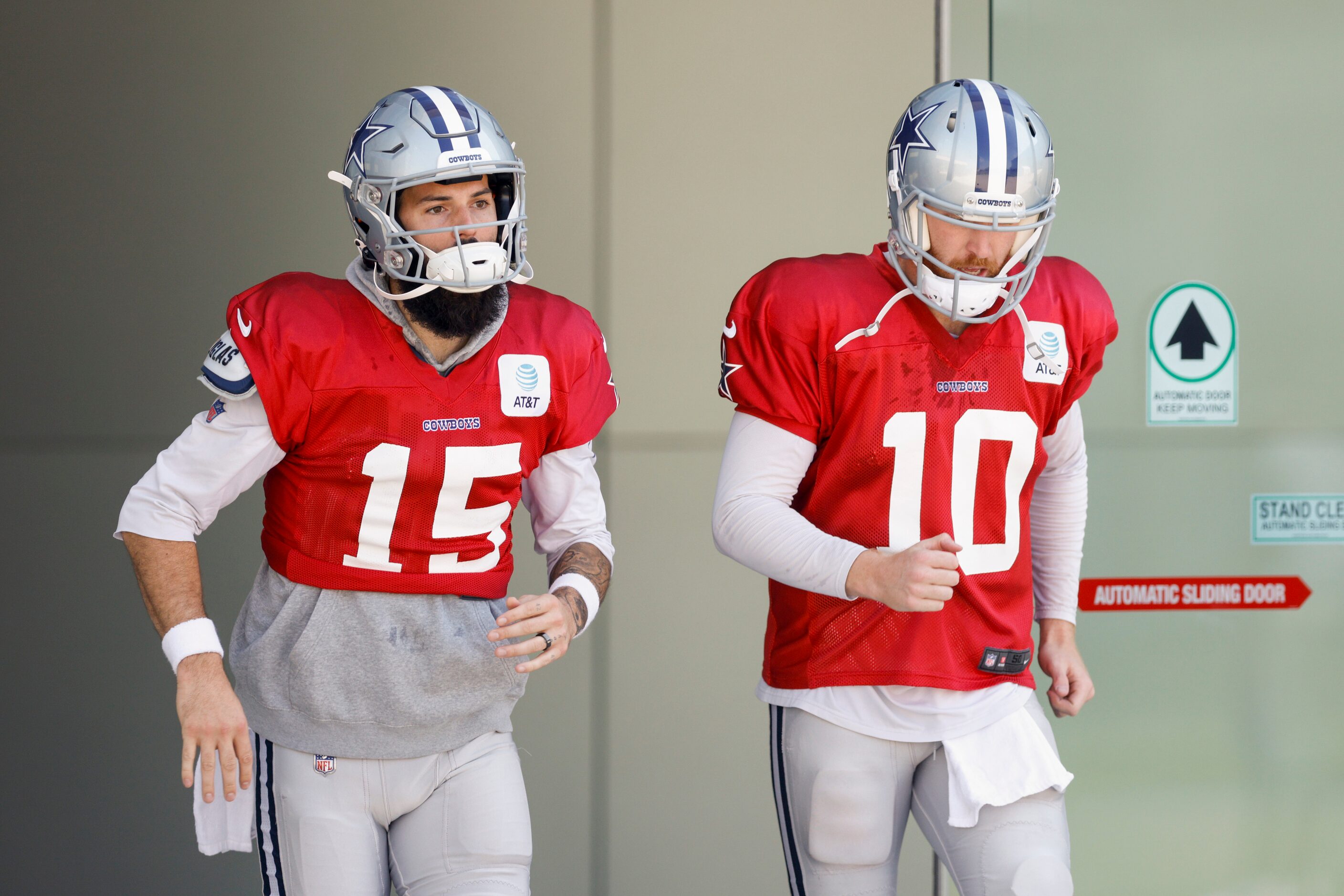 Dallas Cowboys quarterback Will Grier (15) and quarterback Cooper Rush jog out to the field...