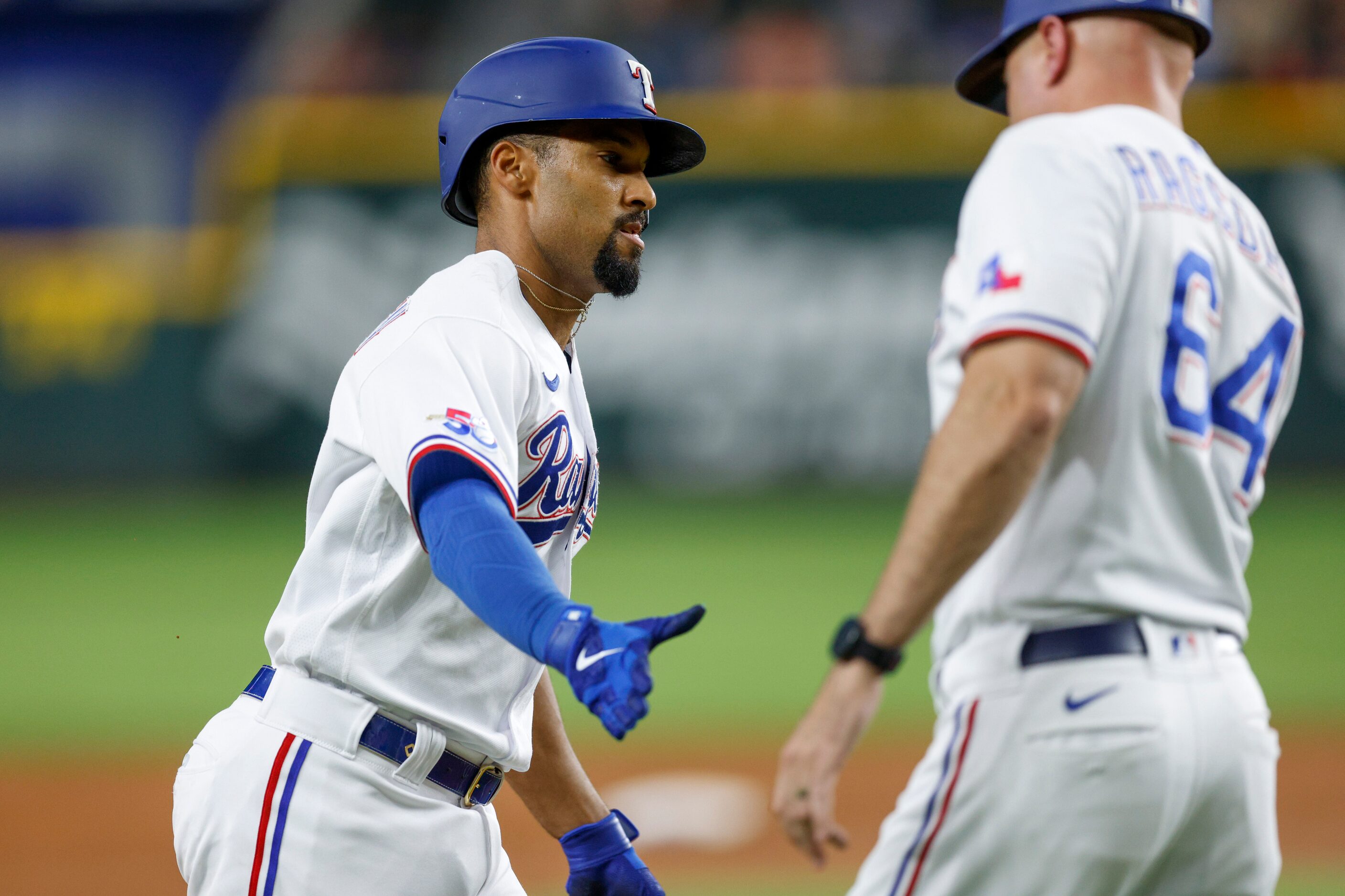 Texas Rangers second baseman Marcus Semien (2) high-fives third base coach Corey Ragsdale...