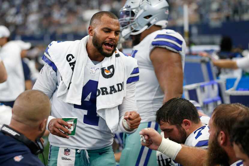 Dallas Cowboys quarterback Dak Prescott (4) celebrates with Dallas Cowboys center Travis...