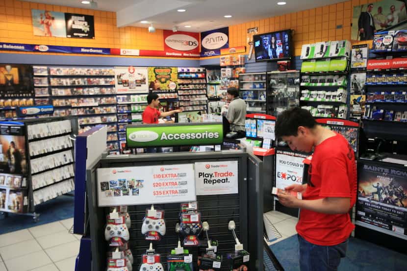 George Nunez, 17, looks at an XBOX 360 video game while browsing the GameStop store at...