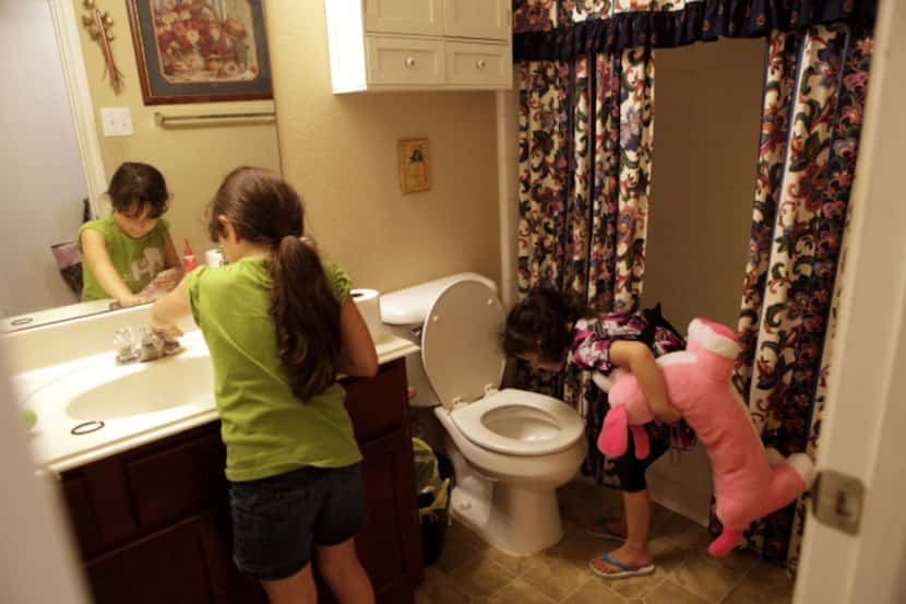 Mia Soto, 6, left, and Mya Soto, 6, checked their bathroom sink and toilet on Thursday to...