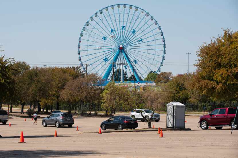 A few vehicles move toward the entrance of the State Fair of Texas Drive-Thru at Fair Park...