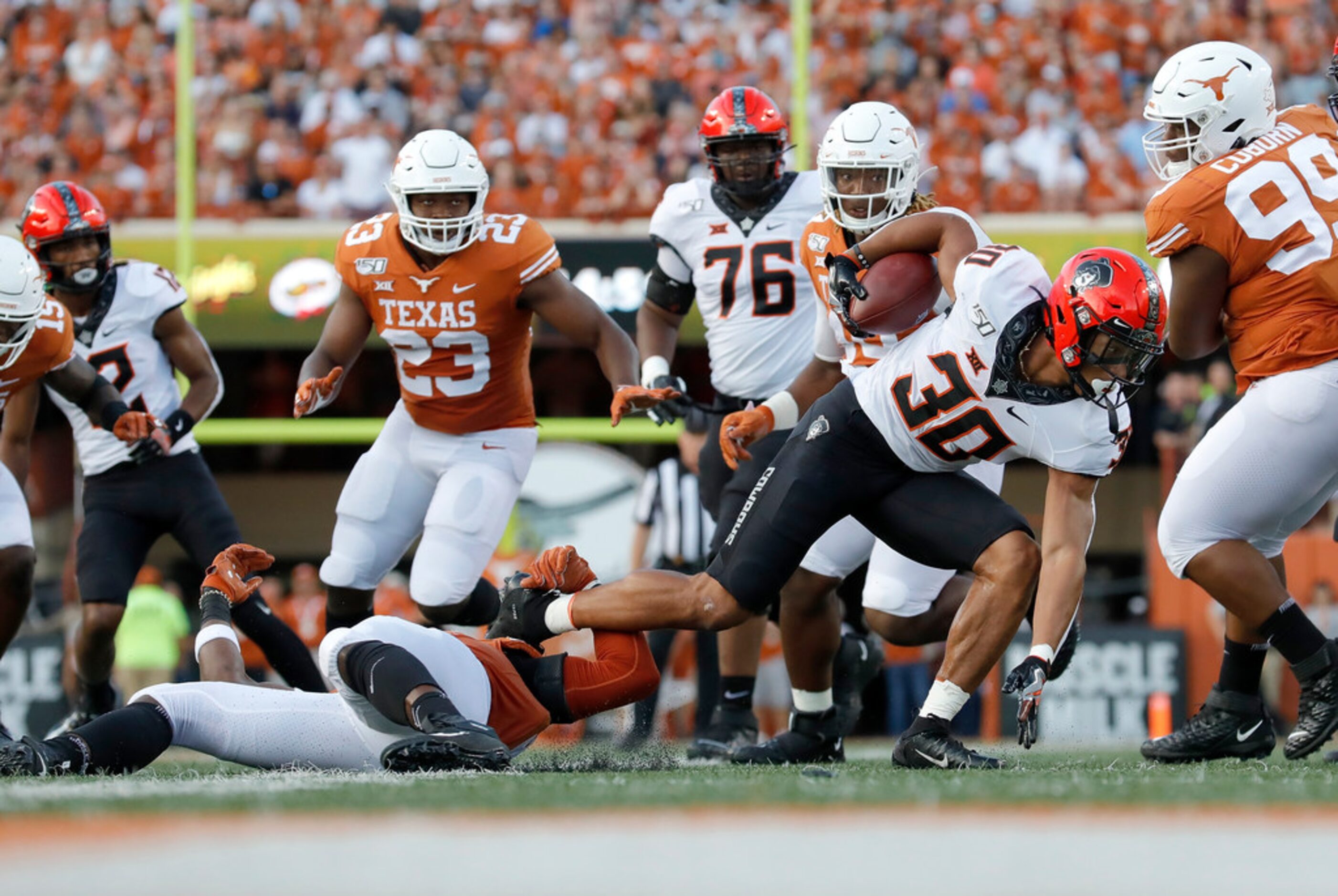 AUSTIN, TX - SEPTEMBER 21:  Chuba Hubbard #30 of the Oklahoma State Cowboys is tripped up by...