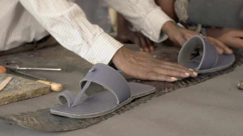 
A worker at Maasai Treads in Nairobi, Kenya, fashions a sandal from old jetliner seat...