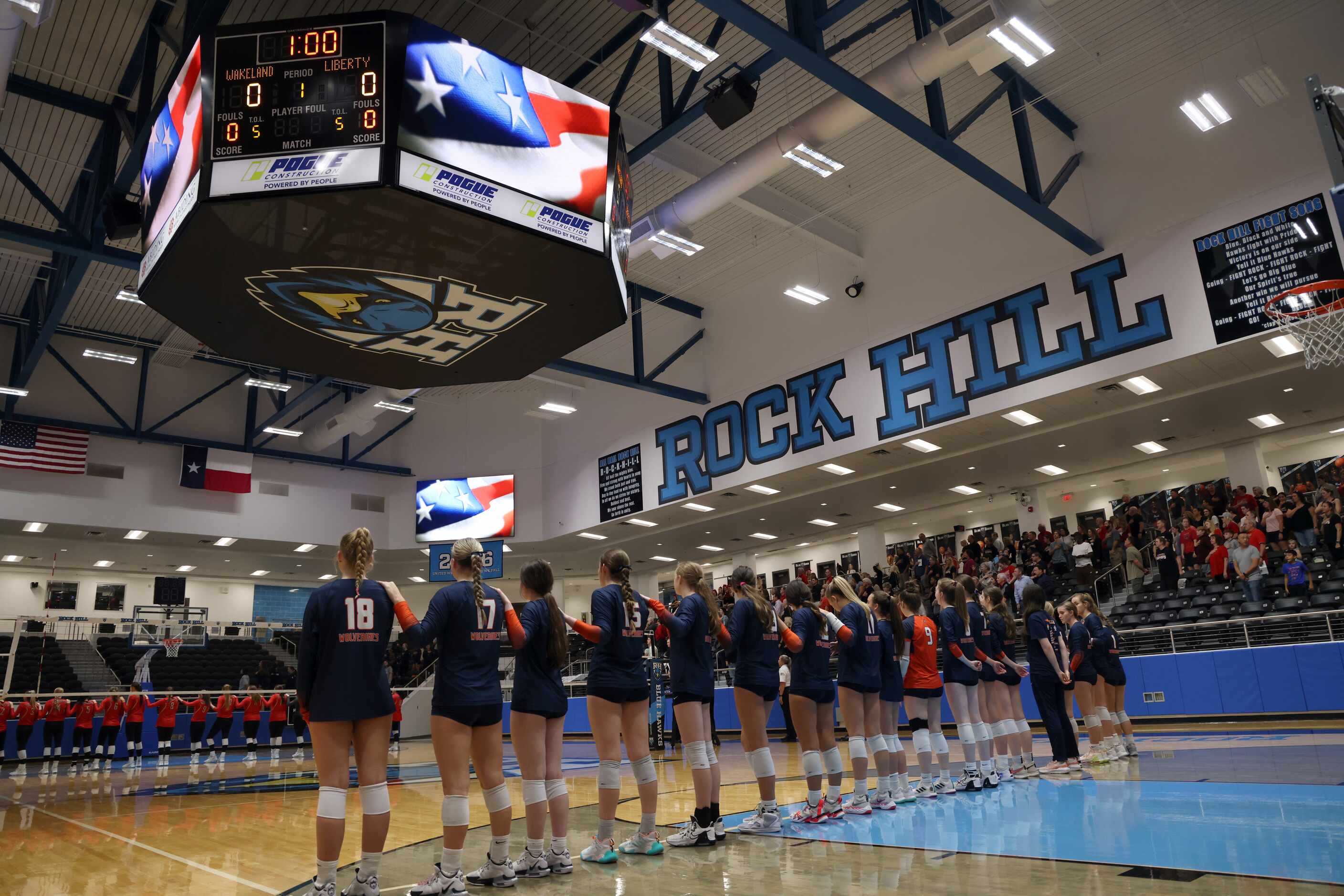 Frisco Liberty players (background) and Frisco Wakeland players pause for the playing of the...