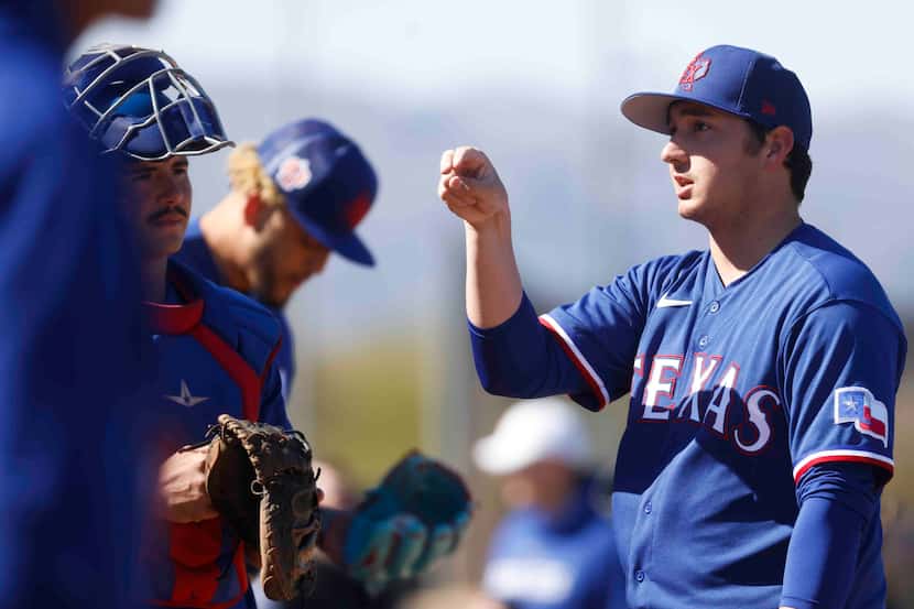Texas Rangers right handed pitcher Owen White interacts with teammates during the first...