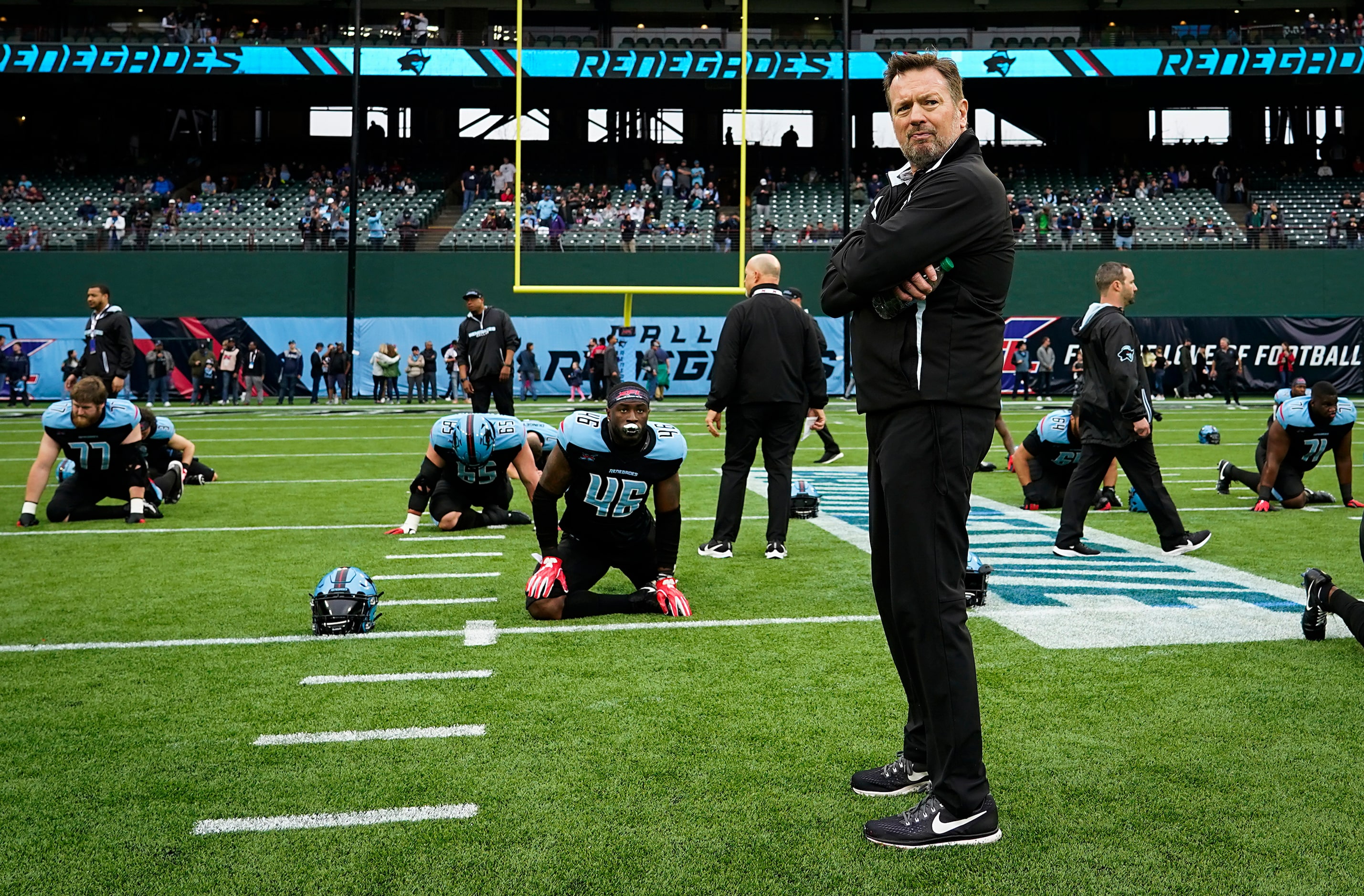 Dallas Renegades head coach Bob Stoops watches his team stretch before an XFL football game...