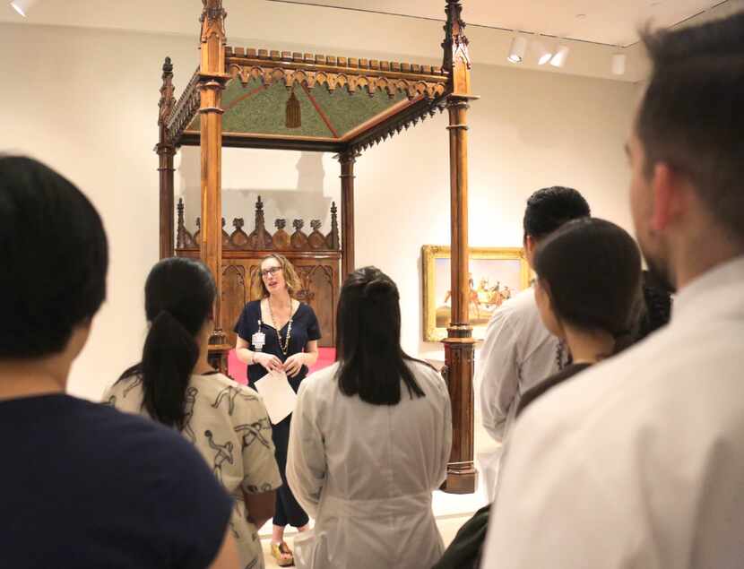 Dr. Heather Wickless of UT Southwestern talks with medical school students about items at...