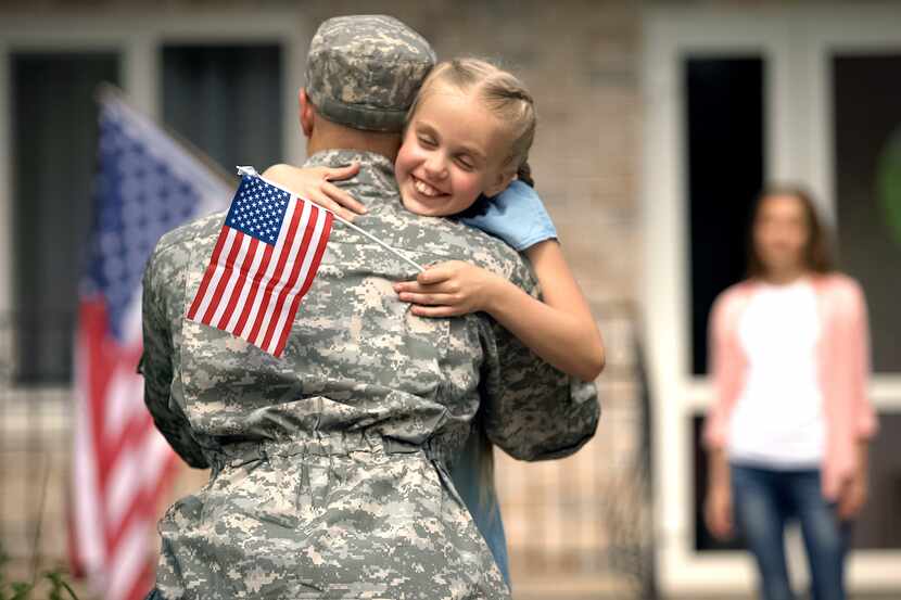 A cheerful daughter hugs her father, a U.S. soldier.