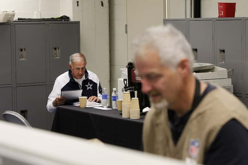 Dallas Cowboys defensive coordinator Monte Kiffin sorts through notes while working in the...