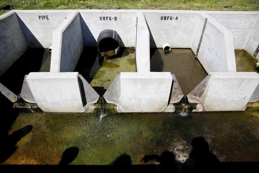 Shadows of members of the media are reflected in the relief well during a tour of Lewisville...