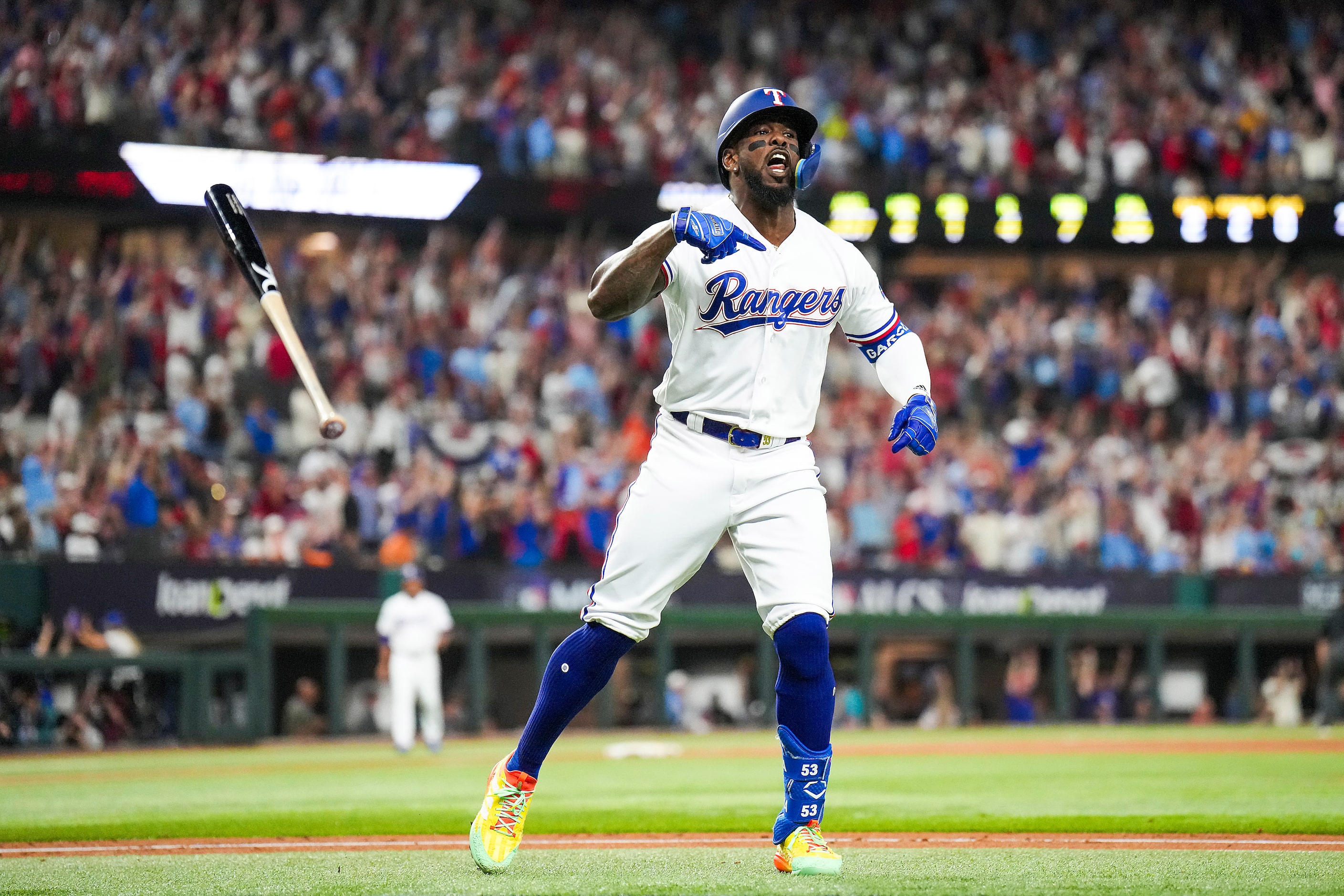 Texas Rangers right fielder Adolis Garcia flips his bat after hitting a solo home run during...