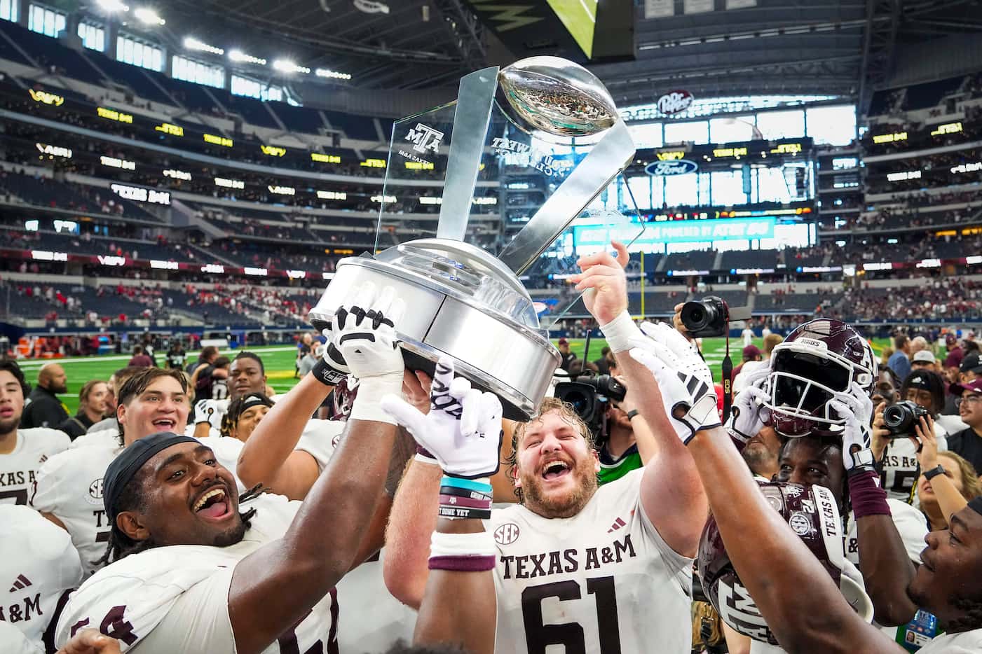 Texas A&M offensive linemen Mark Nabou Jr. (54) and Bryce Foster (61) lift the 2023...