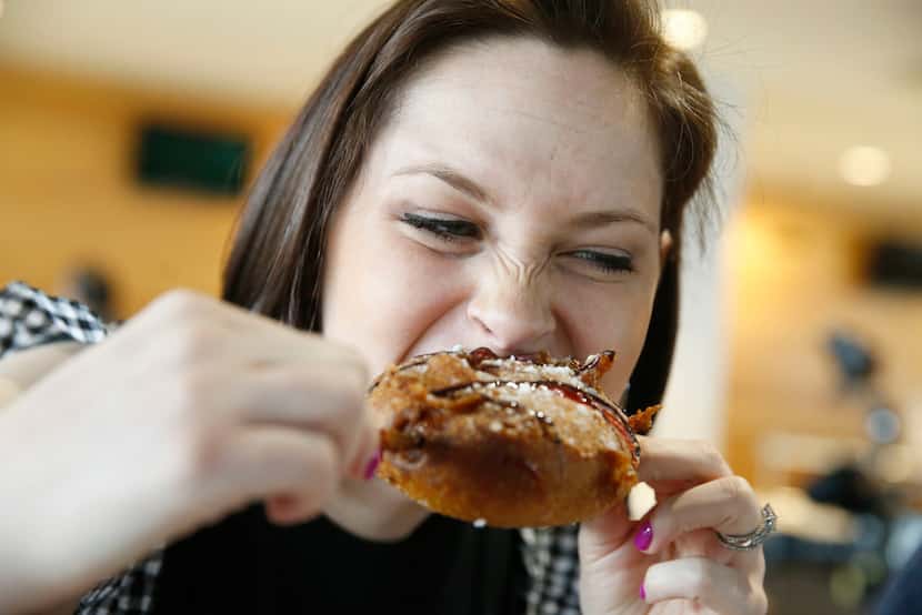 Sarah Blaskovich goes for a big bite of the 7th Inning Cinnamon Roll. It's delicious, y'all.