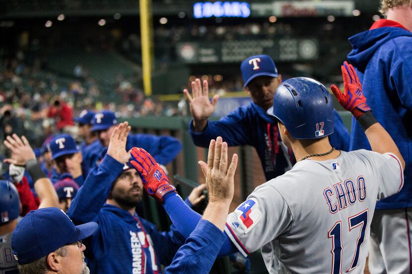 Texas Rangers right fielder Shin-Soo Choo (17) is greeted in the dugout after hitting a...