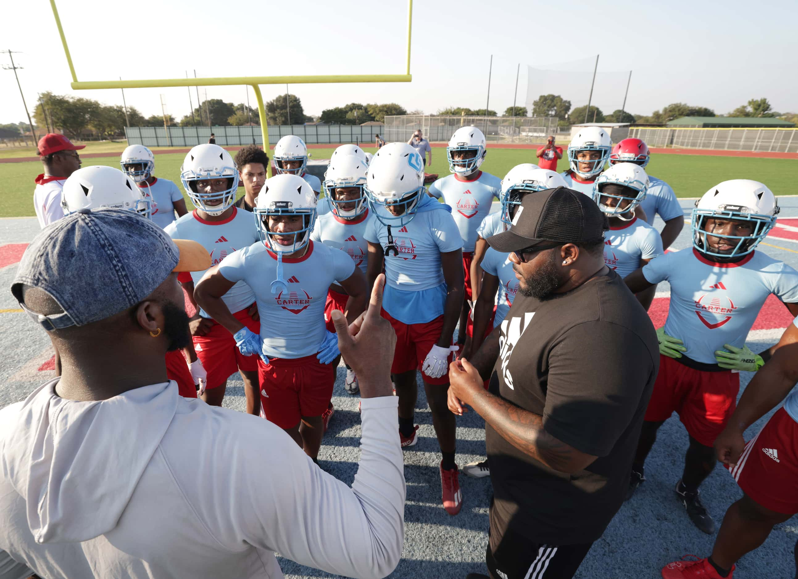 Coaches Deandrae Collins, left, and Billy Wilson motivate players on their first day of...