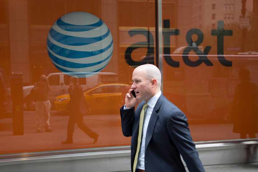 A man using a mobile phone walked past an AT&T store in New York.