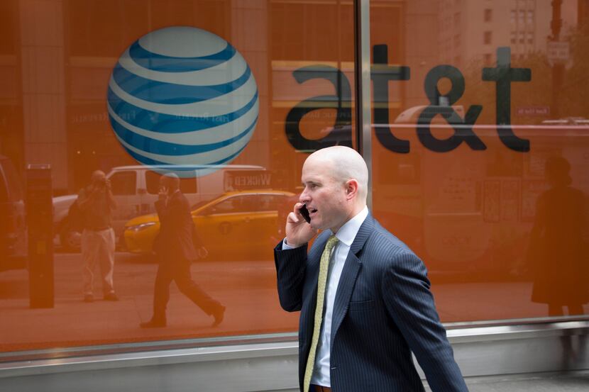 A man using a mobile phone walked past an AT&T store in New York.