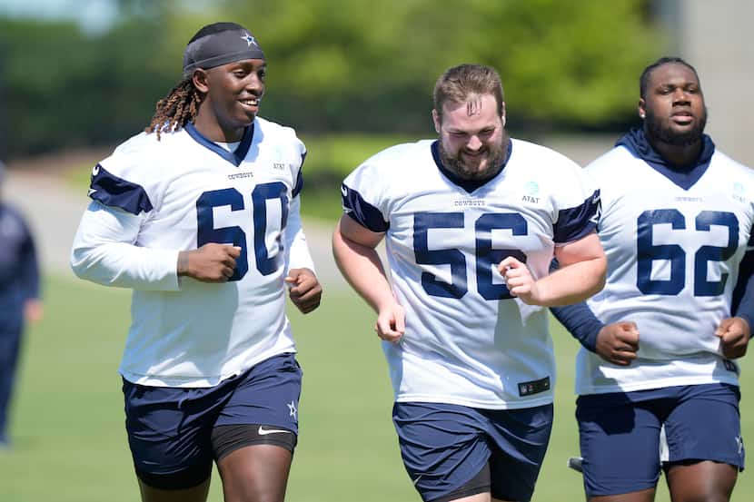 Dallas Cowboys tackle Tyler Guyton (60) jogs with teammate lineman Cooper Beebe (56) during...