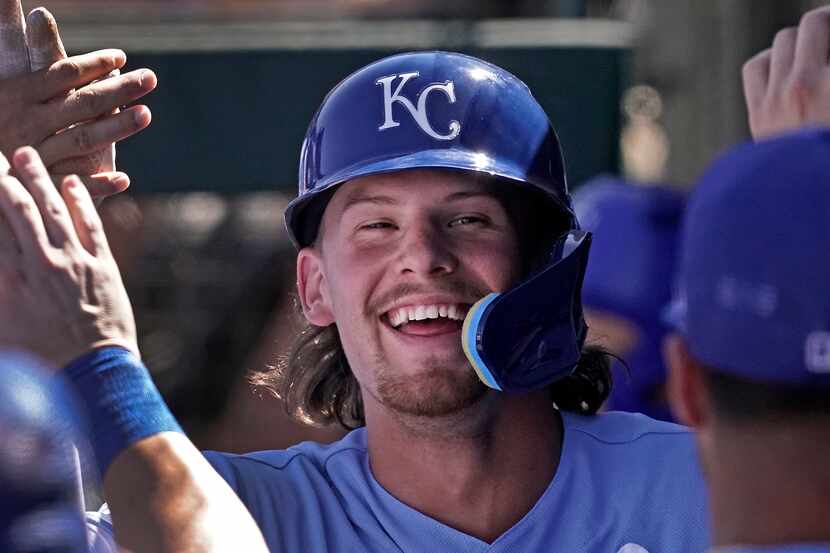 FILE — Kansas City Royals' Bobby Witt Jr. celebrates in the dugout after scoring on a...
