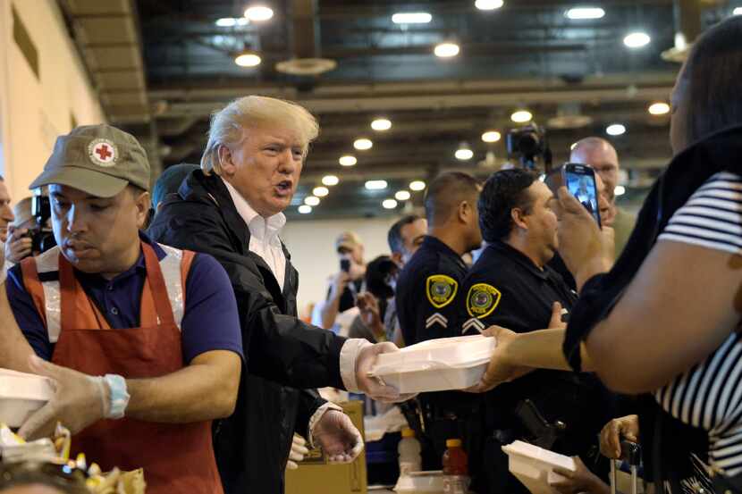 President Donald Trump passes out food and meets people impacted by Hurricane Harvey during...