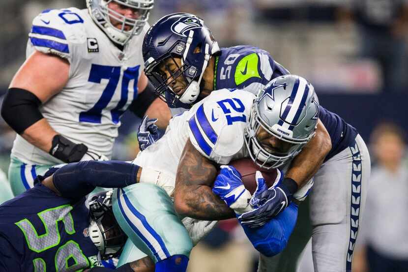 FILE - Cowboys running back Ezekiel Elliott (21) is tackled by Seahawks linebackers Jake...