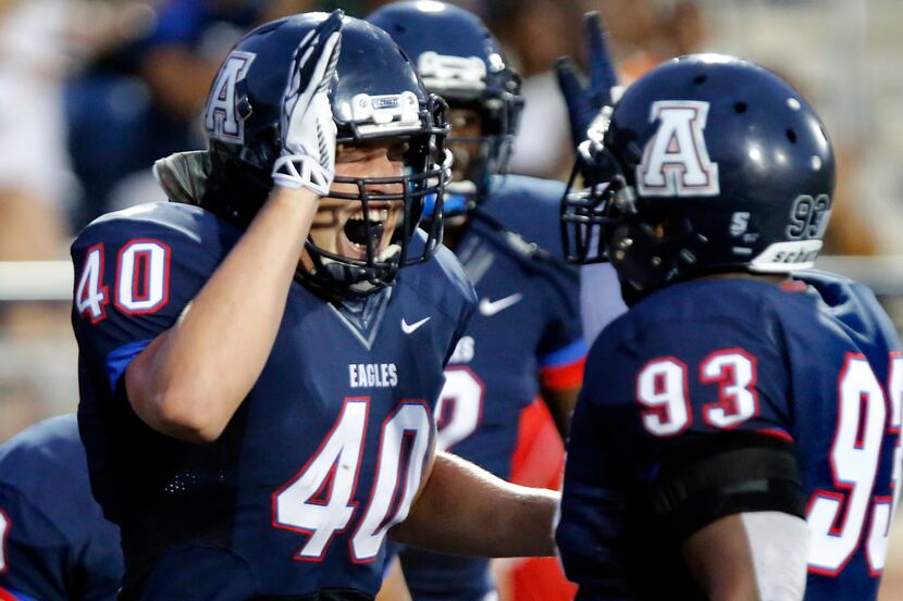 Allen High School linebacker Ryan Johnson (40) celebrates with team mate Marcus Davis (93)...