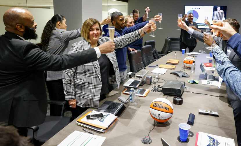 Dallas Wings head coach Latricia Trammell (center) toasts champagne with members of her...