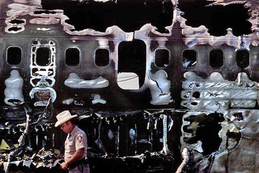  August 31, 1988--A law enforcement officer guards the scene of the fire-damaged fuselage of...