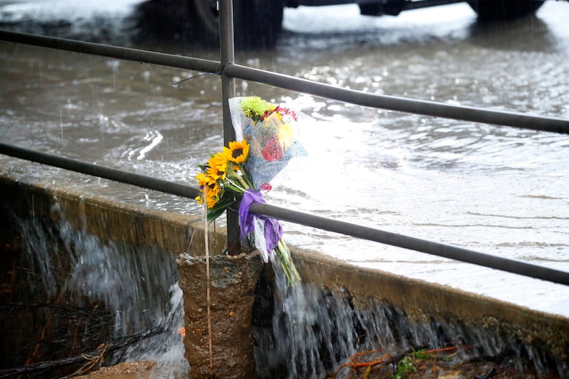 Flowers secured to a railing sustain the flooding rains on Greek Row Drive on the University...