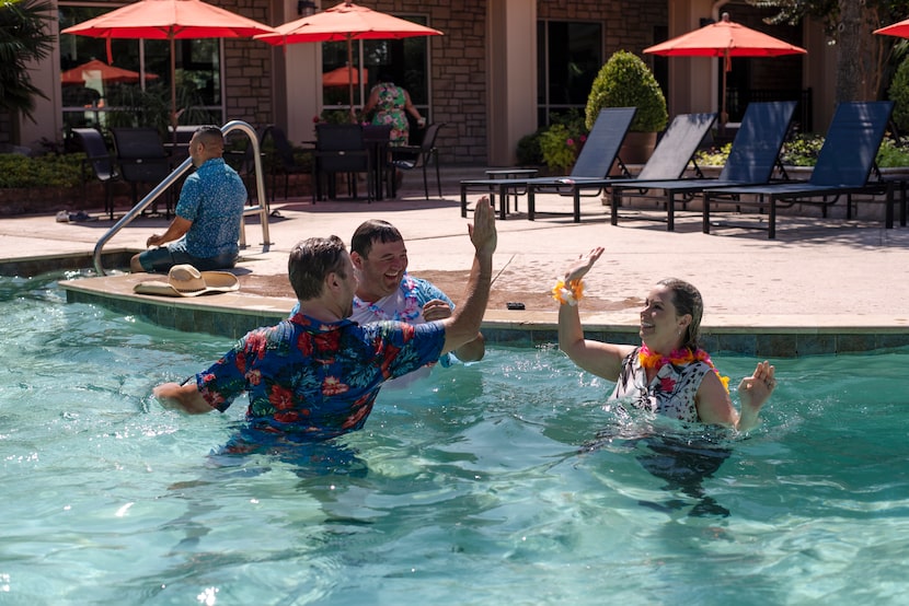 Craig Lashley, left, president of Valiant Residential, high fived Todd Parks and Tanya...