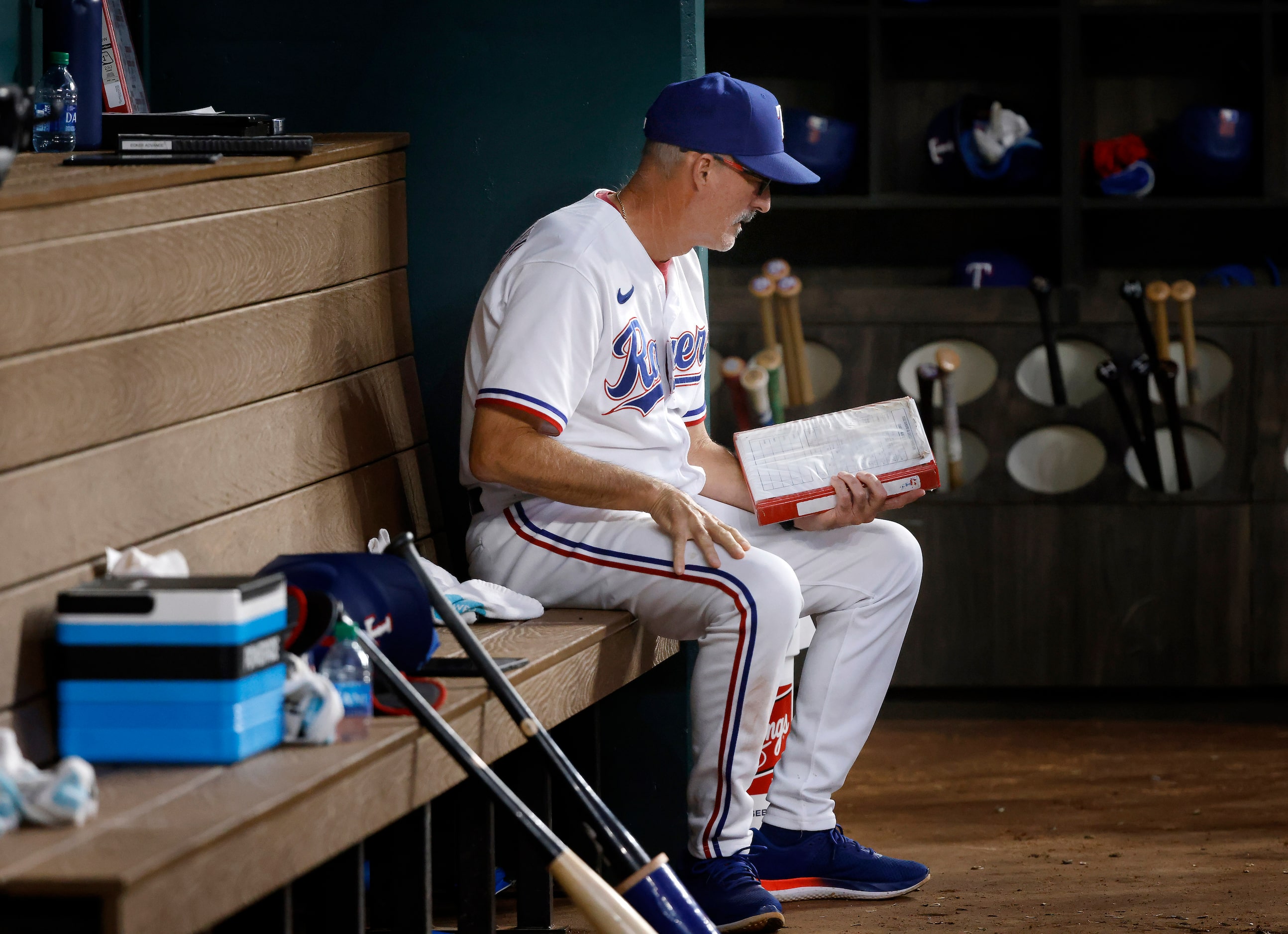 Texas Rangers pitching coach Mike Maddux views his notes during their game against the...