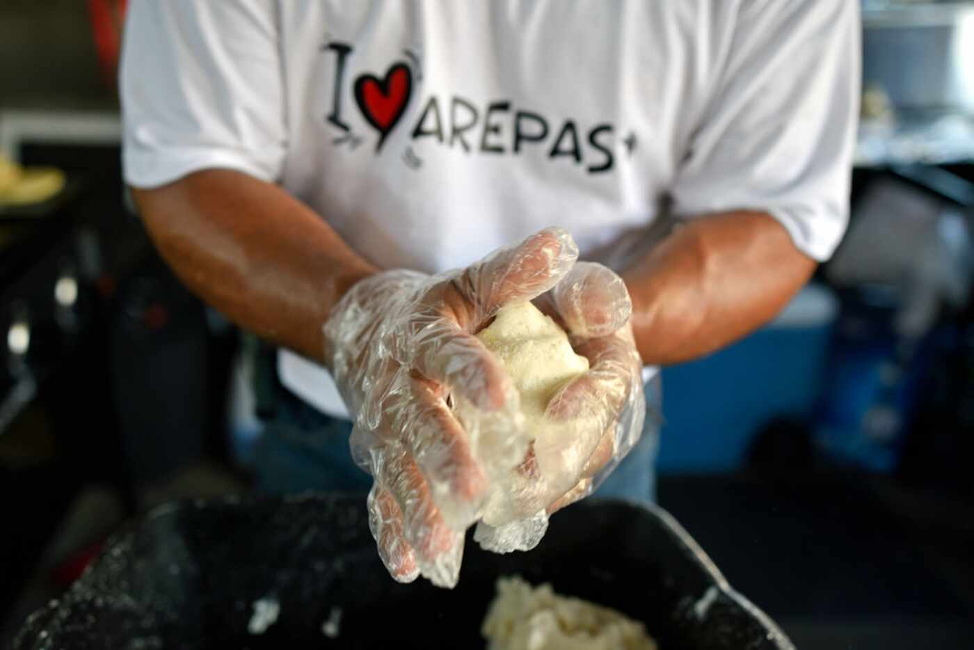 Cesar Hernandez shapes an arepa at the food booth Arepa Nation at the Dallas Farmers Market.