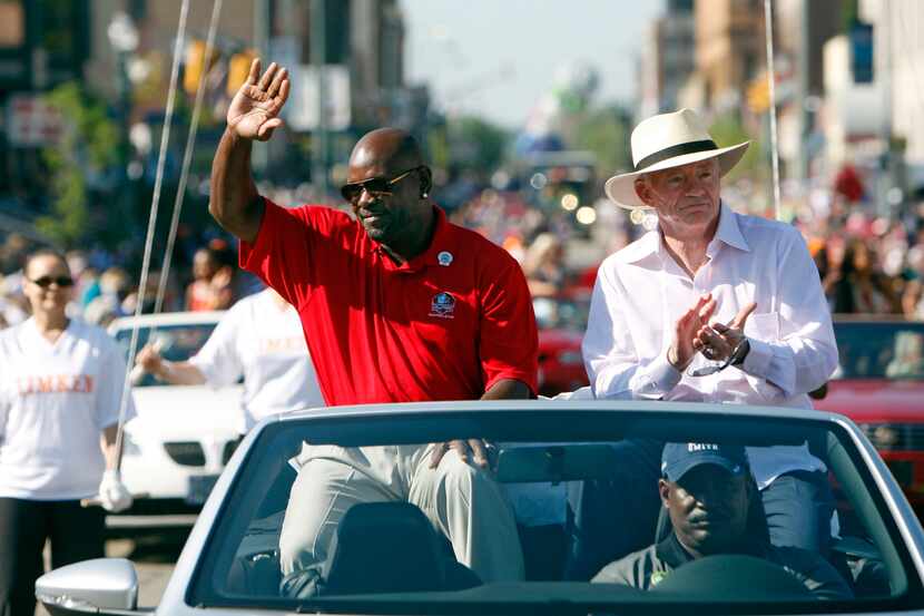 Enshrinee Emmitt Smith and Dallas Cowboys owner Jerry Jones acknowledge the fans as they...