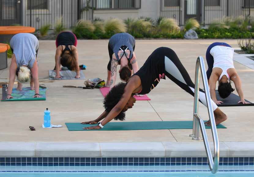 Veleisa Burrell teaches yoga class poolside at Alexan West Dallas apartments.