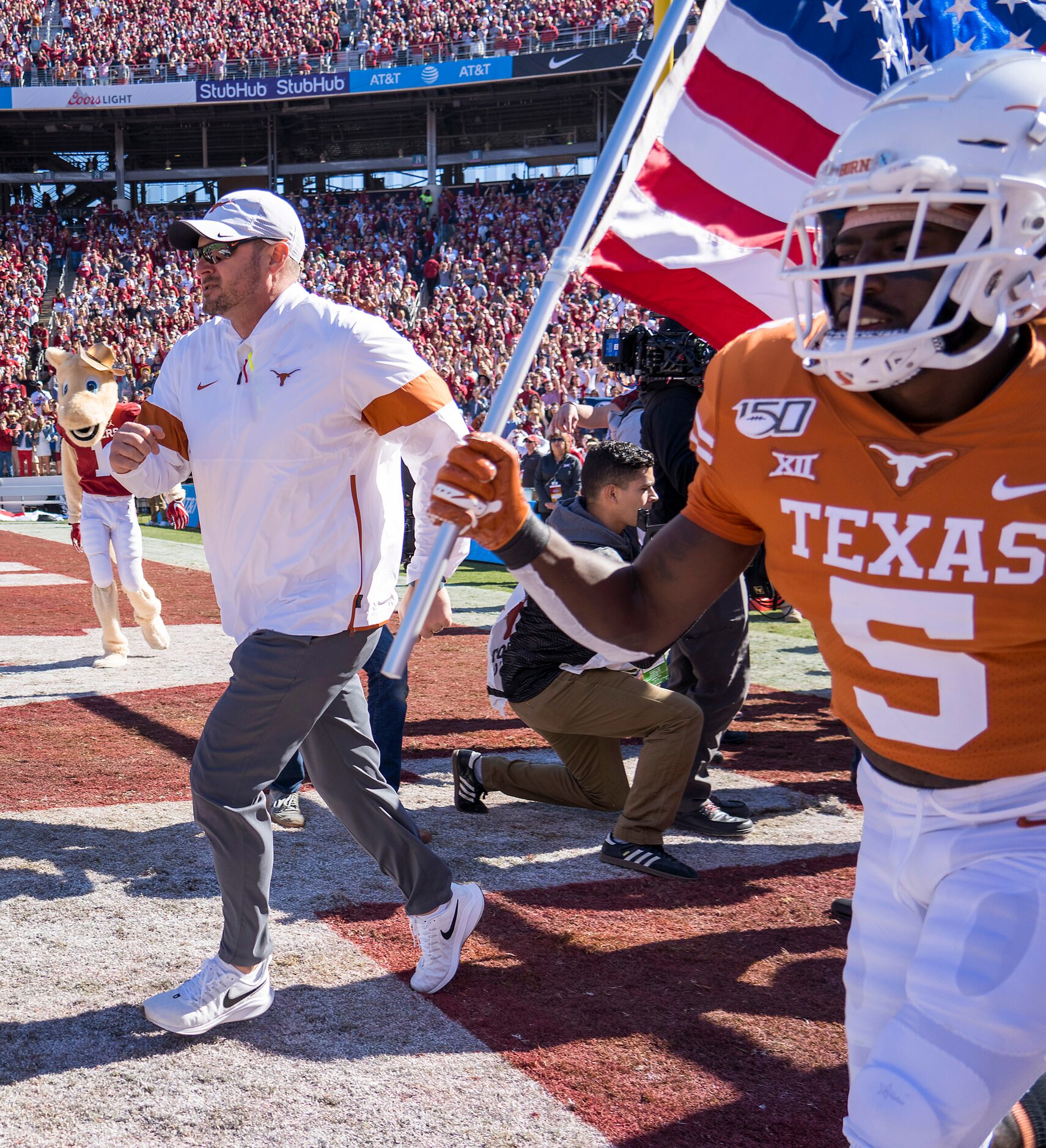 Texas head coach Tom Herman leads his team onto the field before an NCAA football game...