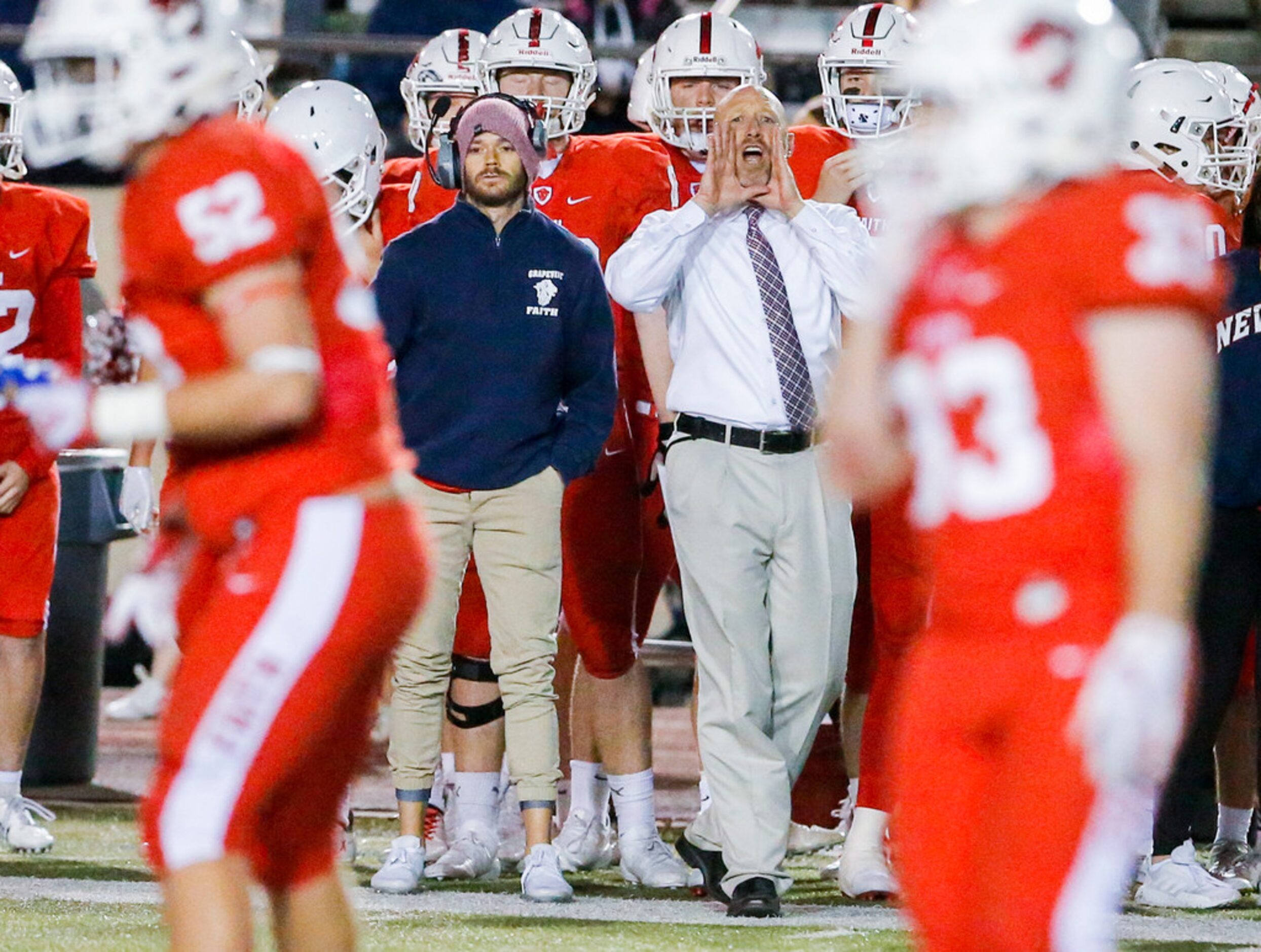 TXHSFB Grapevine Faith head coach Kris Hogan, in the white shirt, shouts instructions to his...