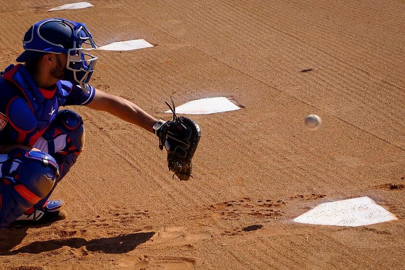 Texas Rangers catcher Isiah Kiner-Falefa catches a bullpen session during a spring training...