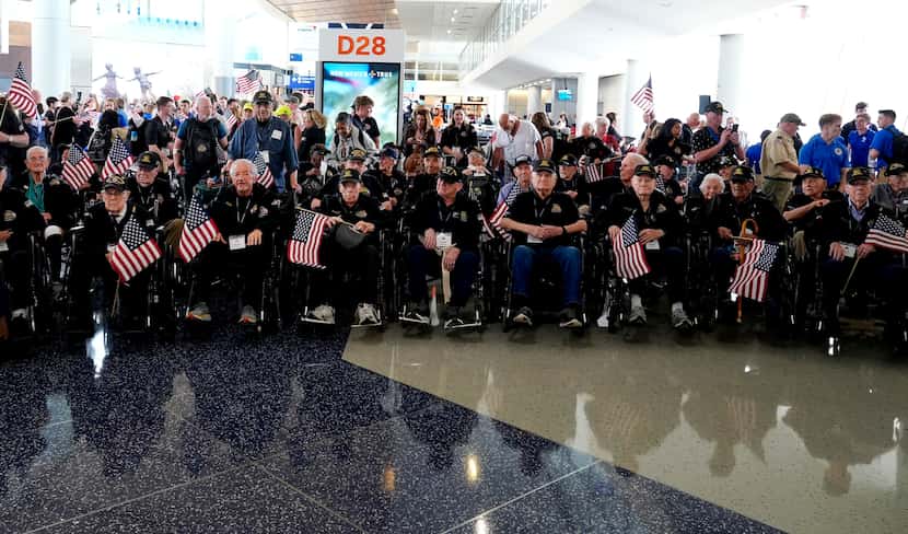A group of World War II veterans wait to board a plane at Dallas Fort Worth International...