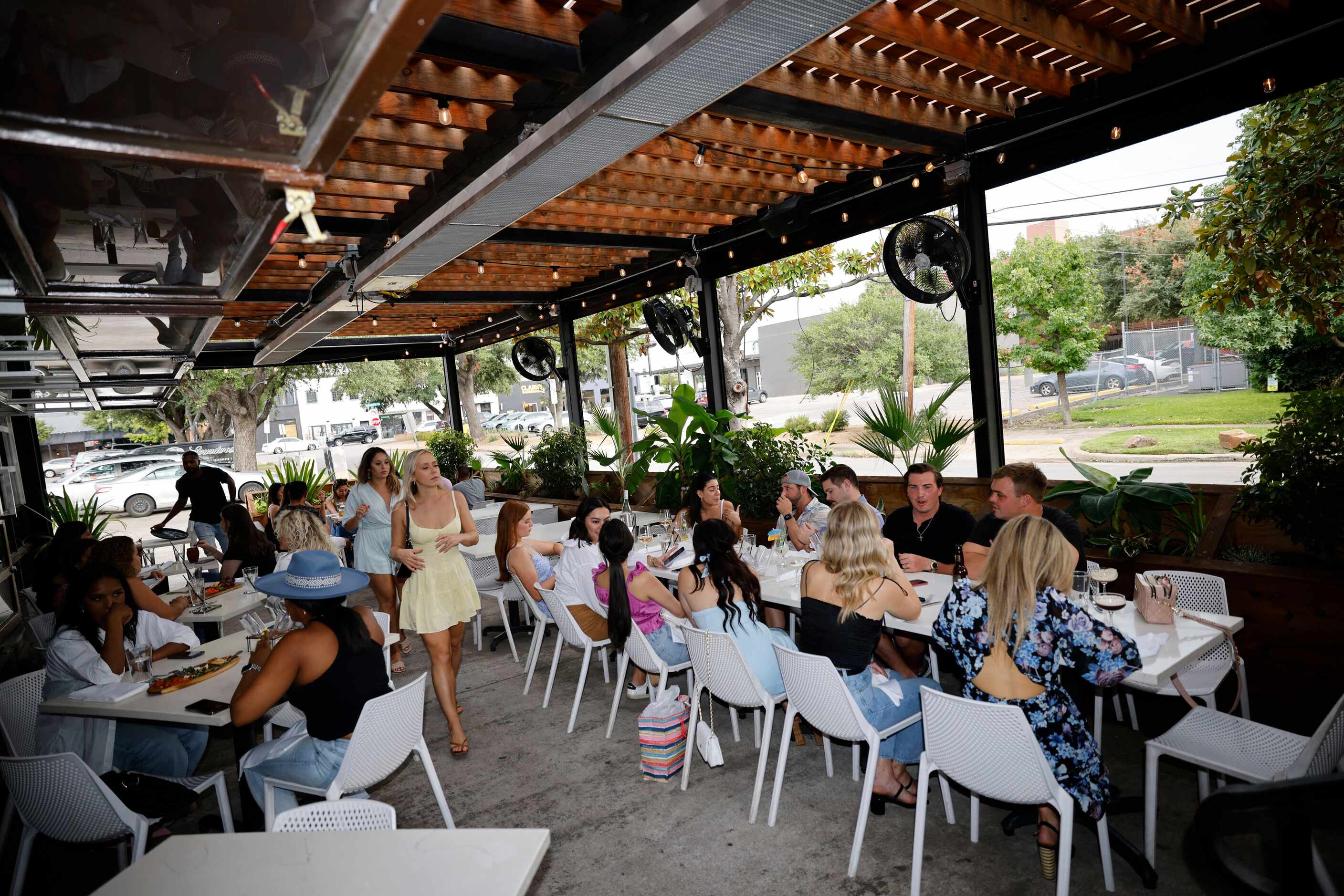 People enjoy dinner sitting on the patio at Leela’s Pizza and Wine in the Lower Greenville...